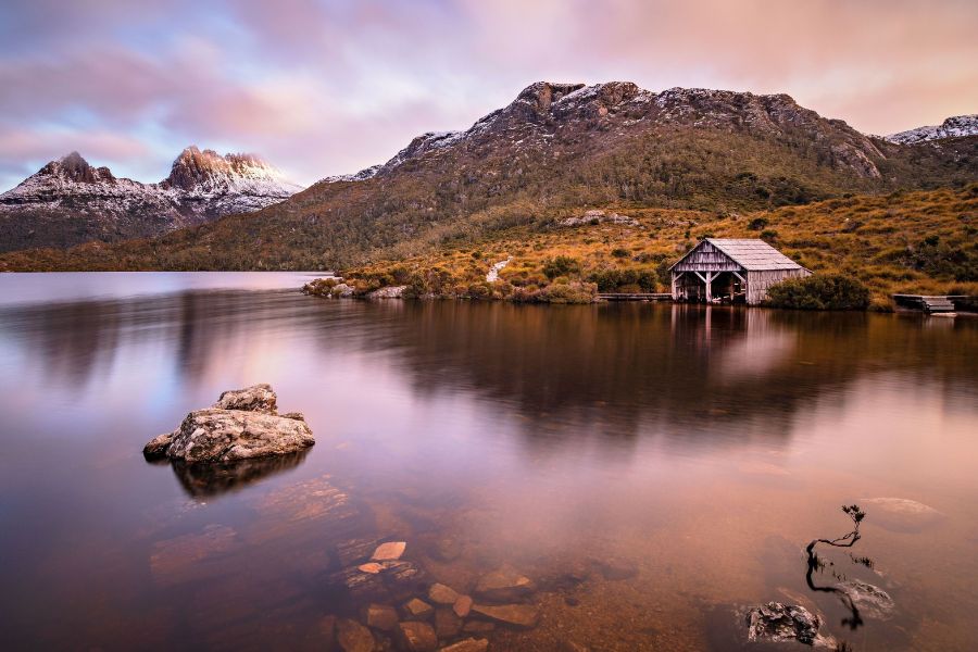 Dove Lake at dawn with the boatshed and Cradle Mountain reflected in still water